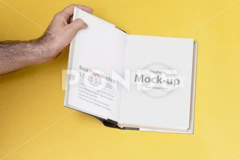 Male hand opened a book-catalog on yellow background mock-up series Modello PSD