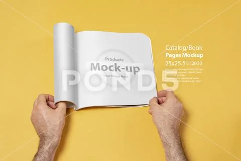 Male hand opened a presentation catalog on yellow backdrop mock-up series PSD Template