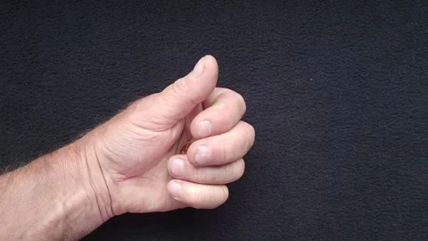 Male hand opens to reveal a single gold Sovereign coin Stock Footage 243989706