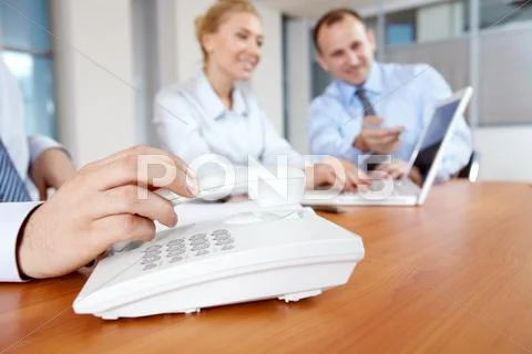 Male hand picking up telephone receiver in board room Stock Photos