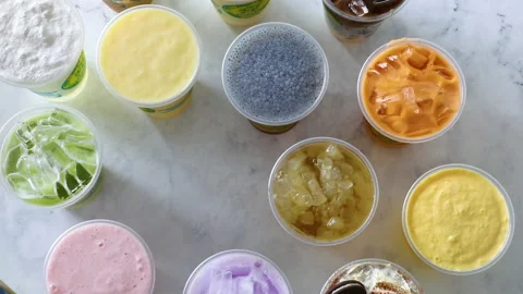 Male hand placing down ice tea with boba onto flat lay table setting. Stock Footage 161208048