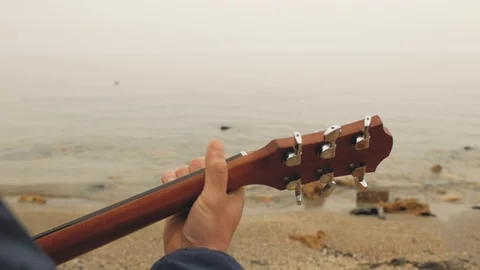 Male hand playing over the chords on the guitar against the background of the Stock Footage 103445321