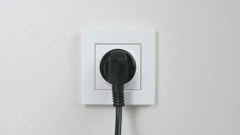 Male hand plugging and unplugging plug into white wall socket Stock Footage 231405820