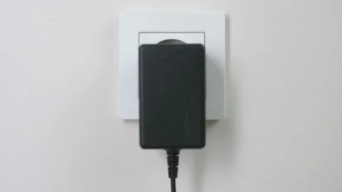 Male hand plugging and unplugging plug into white wall socket Stock Footage 231406033