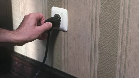 Male hand plugging plug into wall socket. Close-up power socket Stock Footage 320293651