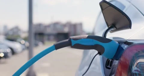 Male hand plugging in power cable in charging socket of electric car. Stock Footage 212977857