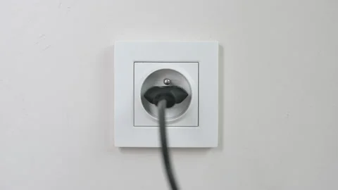 Male hand plugging unplugging charger cable plug into white wall power socket Stock Footage 232769732