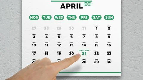 A male hand points finger to the Eid al-Fitr date on a calendar April page 2023 Stock Photos