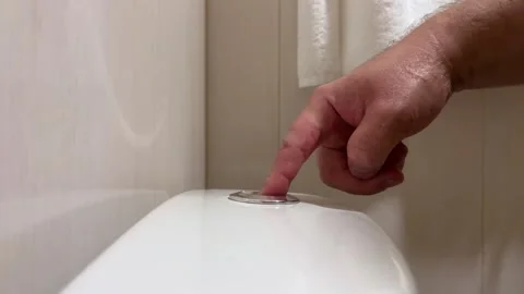 Male hand presses touch flush button on ceramic toilet cistern Stock Footage 340427878