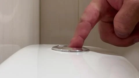 Male hand presses touch flush button on ceramic toilet cistern in public WC Stock Footage 345601526