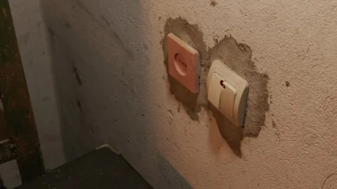 Male Hand Pressing Light Switch on Unfinished Concrete Wall in Dark Room Stock Footage 335636887