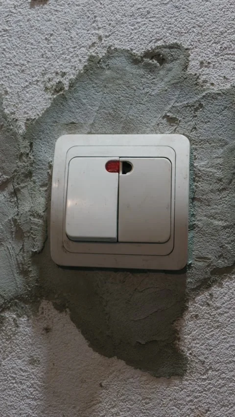 Male Hand Pressing Light Switch on Unfinished Wall in Dark Room Stock Footage 335640474