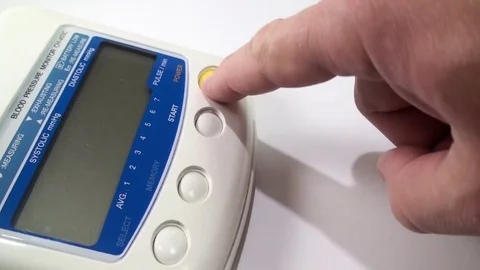 Male hand pressing power button on blood pressure Stock Footage