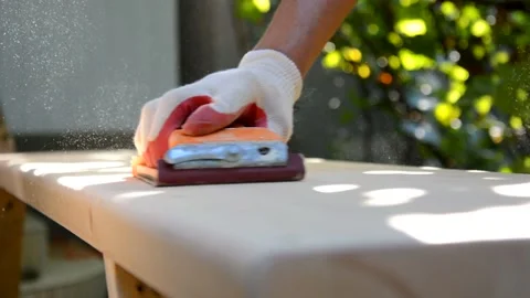A male hand in protective gloves doing carpentry work and sanding a wooden table Stock Footage 163173903