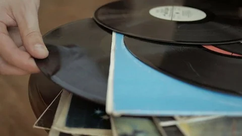Male hand pulls old and used vinyl record out of its cover in the LP stack. Stock Footage 69218965