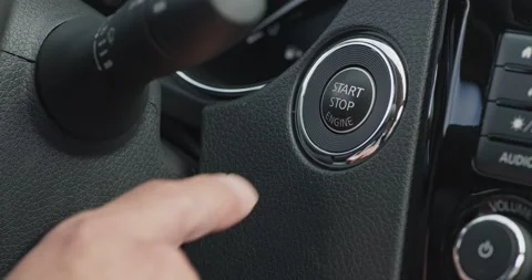 Male hand pushing power button to start keyless ignition hybrid car engine Stock Footage 138507780
