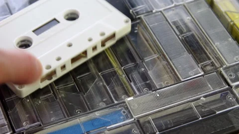 Male hand put down white audio cassette on a set of audio cassettes in cases 스톡 동영상 133533628