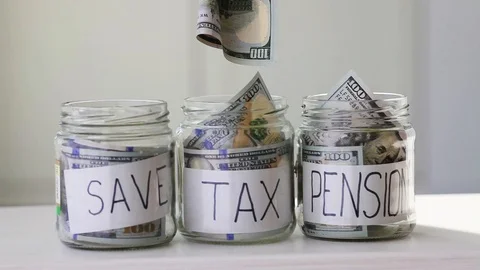 Male hand puts 100 dollars in a glass jar with the text  tax . Stock Footage 126399331