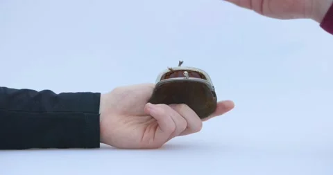 Male hand puts a cryptocoin, Bitcoin or BTC, in a small brown wallet, depicting Stock Footage 172257761