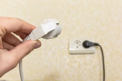 Male hand puts plug in the socket Foto stock