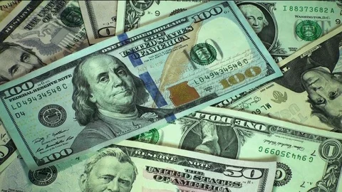 Male hand putting bundle of dollar bills on the money banknotes heap. Stock Footage 77861371