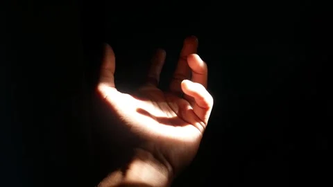 Male hand reaching for light in darkness on isolated black background. Stock Footage 304723217