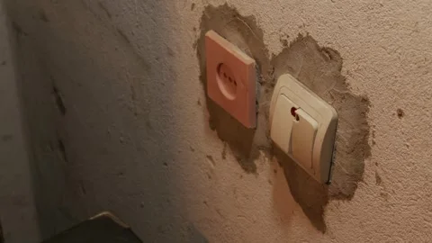 Male Hand Reaching for Light Switch on Rough Plaster Wall in Red Light Stock Footage 335642367