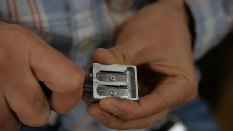 Male hand sharpens a pencil on the sharpener Stock Footage 99583012