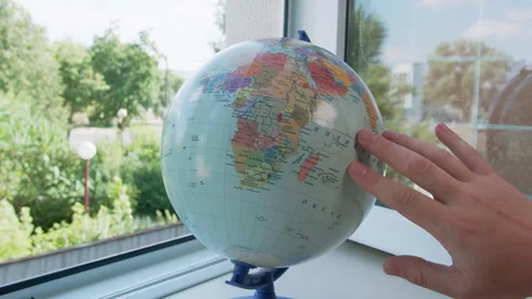 Male Hand Spins Globe by Window, Planning Journeys Stock Footage 324136405