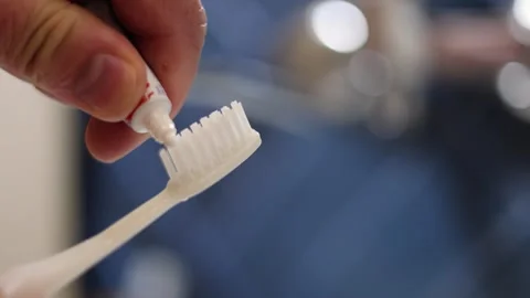 Male hand spreading toothpaste on disposable plastic toothbrush Stock Footage 309964582