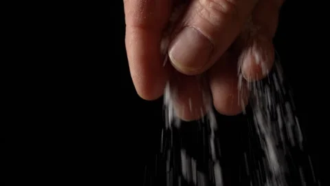 Male hand sprinkling or adding salt on black background to dish, slow motion Stock Footage 306655602