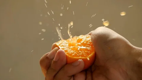 Male hand squeezing fresh orange juice in slow motion Vídeo Stock 114689986