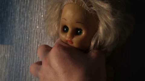 Male hand strangles a doll in the form of a little girl, close-up Stock Footage 196592431