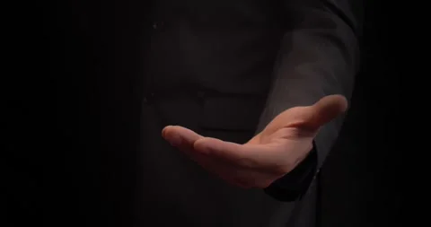 A male hand in a suit is extended forward with an open palm up. The gesture of Stock Footage 271035173