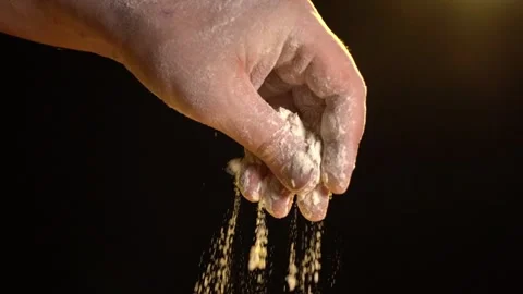 Male hand throws flour on a black background. cooking baking concept Vidéo 146602111