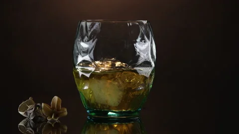 A male hand throws ice cubes into a glass of whiskey. Stock Footage 150664207
