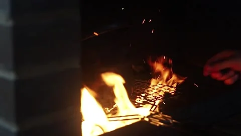 Male hand throws a splinter into the fire of a fireplace Stock Footage 135012237