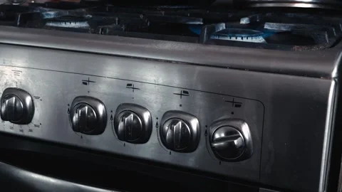 Male hand turning control knob of stainless steel gas stove. Adjusting heat and Stock-Footage 339865175