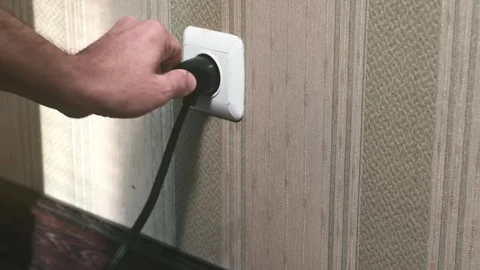 Male hand unplugging plug into wall socket. Close-up power socket Stock Footage 320293664
