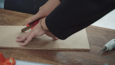 Male hand using cutter knife on a cardboard package - homemade word craft Stock Footage 197742017