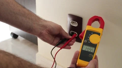 Male hand using digital multimeter to test the voltage of wall power outlet. Video stock 321661284