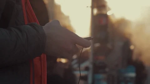 Male hand using smartphone with a headset on street Video stock 75178283