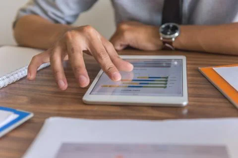Male hand using tablet to read financial data Foto stock