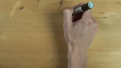 Male hand writes down caloric content of apple on wooden surface Stock Footage 82904850