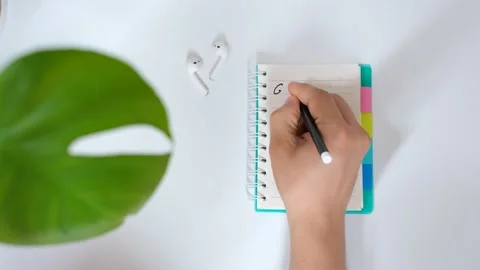 Male hand writes goals in notebook on white background top view. Stock Footage 166074885