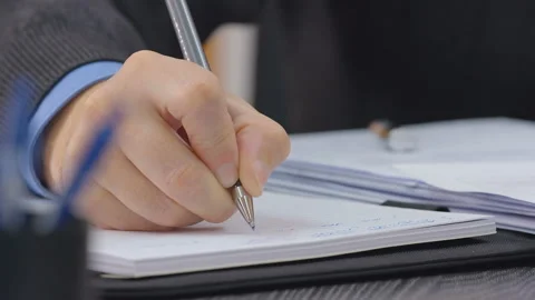 Male hand writes with a pen in a notebook. Closeup. Dolly shot Stock Footage 161953723