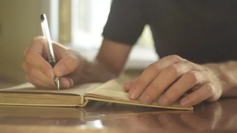 Male hand writing in notebook with pen Stock Footage