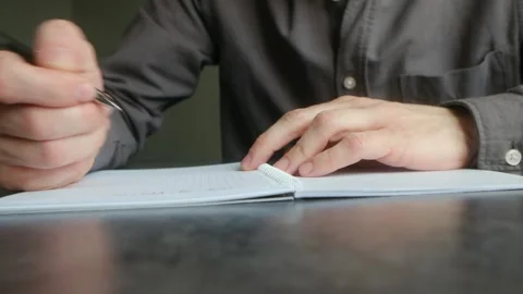 Male hand writing notes with a pen in a notebook Stock Footage 337892314