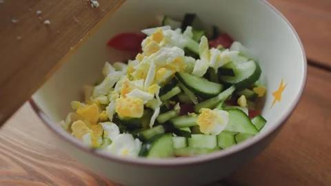 Male hands adding boiled egg to salad Stock Footage 246883291