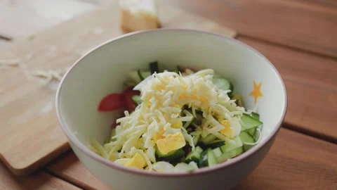 Male hands adding cheese to salad Stock Footage 246883578